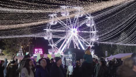 Noria-Iluminada-Y-Luces-Navideñas-En-Un-Concurrido-Parque-De-Atracciones-Por-La-Noche