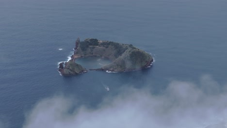 Aerial-view-of-Ilhéu-de-Vila-Franca-do-Campo-with-low-clouds,-azores