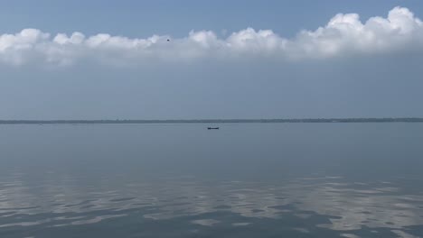 pov-shot-A-small-boat-is-moving-in-the-middle-of-the-water-and-mountains-are-visible-in-the-distance