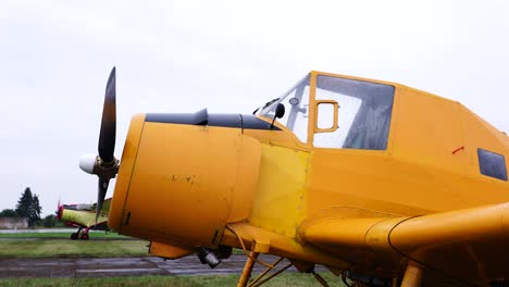 Old-airplanes-parked-on-airport-green-grass-field-during-overcast-day