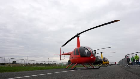 Helicópteros-Ligeros-Estacionados-Detrás-De-Una-Valla-En-La-Rampa-Del-Aeropuerto-Durante-El-Espectáculo-Aéreo