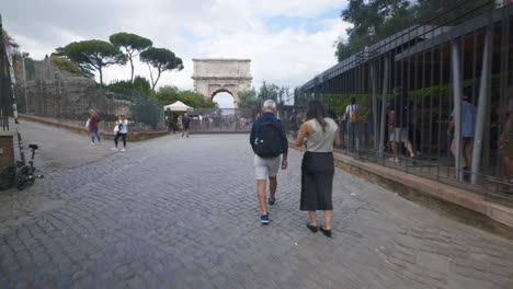 Punto-De-Vista-Inmersivo-En-Roma:-Moverse-Por-Calles-Concurridas-Hasta-Chiesa-Santi-Luca-E-Martina,-Italia,-Europa,-Caminar,-Tembloroso,-4k-|-Viajeros-Mirando-El-Arco