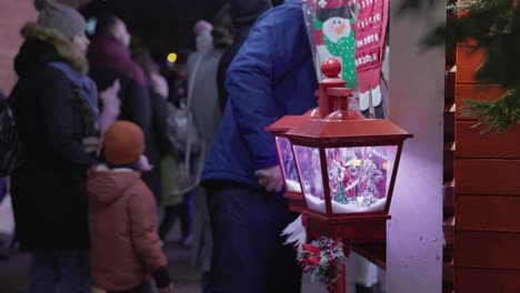 A-Young-Boy-Observing-the-Christmas-Hanging-Lamp-While-Eating-Cotton-Candy-in-the-Park-as-Part-of-the-Galati-National-Day-Celebration-in-Romania---Medium-Shot