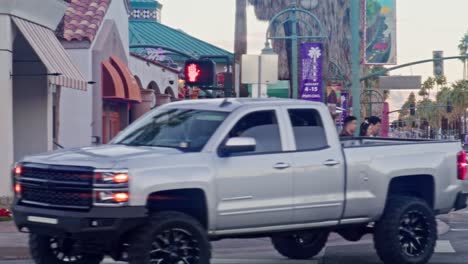 Pedestrians-and-cars-in-downtown-Palm-Springs,-California-with-pan,-slow-motion-and-lens-flare-effect