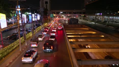 Reihen-Von-Fahrzeugen,-Die-Während-Einer-Nächtlichen-Hauptverkehrszeit-Auf-Einer-Hauptverkehrsstraße-In-Einem-Belebten-Touristenviertel-In-Südostasien-Im-Verkehr-Stecken-Bleiben