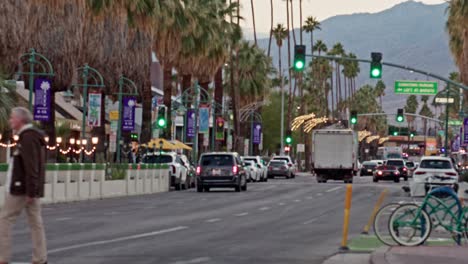 Incline-Hacia-Abajo-Desde-La-Vista-De-La-Montaña-Y-Las-Palmeras-Hasta-El-Tráfico-Y-Los-Peatones-En-El-Centro-De-Palm-Springs,-California