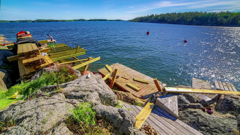 Couple-building-a-jetty-on-the-shore-of-a-lake,-timelapse