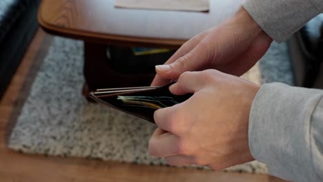 Man-removes-Norwegian-Krone-bills-from-wallet-to-count