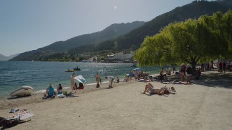 Gente-Bajo-El-Sol-En-La-Playa-De-La-Bahía-De-Queenstown-En-Nueva-Zelanda