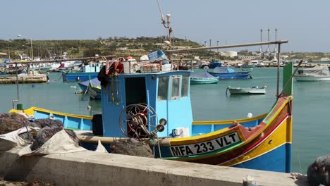 Fischerboot-Vor-Anker-Im-Hafen-Von-Marsaxlokk,-Weitere-Boote-Im-Hintergrund