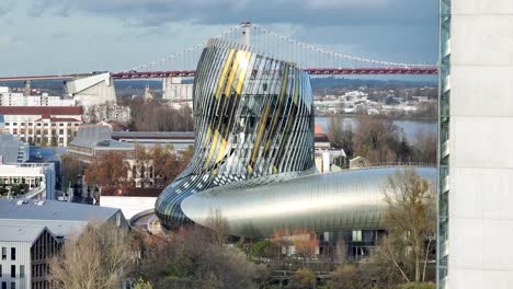 City-of-Wine-museum-building-and-Jacques-Chaban-Delmas-bridge-towers-in-Bordeaux-France,-Aerial-dolly-right-shot