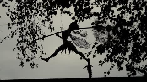 High-Contrast-Footage-Of-A-Wire-Fairy-Holding-A-Dandelion-On-A-Rooftop,-In-Trentham-Estate-Gardens