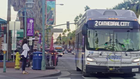 Public-bus-driving-in-downtown-Palm-Springs,-California-in-slow-motion-with-lens-flare-effect