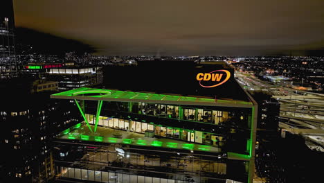 Aerial-view-descending-in-front-of-the-CDW's-new-office,-cloudy-night-in-Chicago