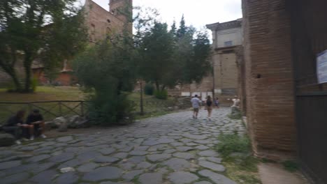 Rome-Immersive-POV:-Moving-In-Busy-Streets-to-Chiesa-Santi-Luca-e-Martina,-Italy,-Europe,-Walking,-Shaky,-4K-|-Gate-Reverse-with-Tourist-Waving