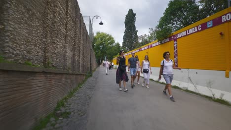 Punto-De-Vista-Inmersivo-En-Roma:-Moverse-Por-Calles-Concurridas-Hasta-Chiesa-Santi-Luca-E-Martina,-Italia,-Europa,-Caminar,-Tembloroso,-4k-|-Grupo-De-Turistas-En-Pequeño-Sendero