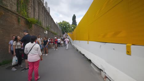 Punto-De-Vista-Inmersivo-En-Roma:-Moverse-Por-Calles-Concurridas-Hasta-Chiesa-Santi-Luca-E-Martina,-Italia,-Europa,-Caminar,-Tembloroso,-4k-|-Fila-De-Turistas-Esperando-Cerca-De-Las-Ruinas