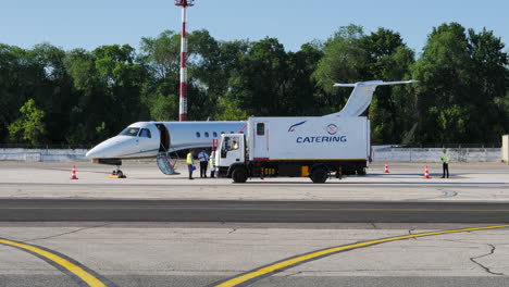 Camión-De-Catering-Que-Llega-Al-Jet-De-Negocios-Estacionado-En-El-Aeropuerto-De-Chisinau,-Estático