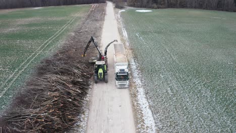 Vista-Aérea-De-Maquinaria-Trituradora-De-Madera-Pesada-Soplar-Madera-Triturada-En-El-Remolque