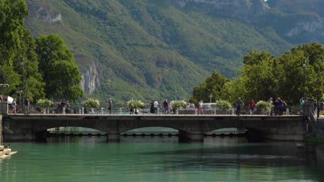 La-Gente-Camina-Sobre-Un-Puente-De-Piedra-Sobre-Este-Lugar-Donde-El-Río-Pasa-Por-La-Antigua-Ciudad-De-Annecy.