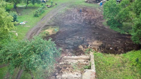 Aerial-reveal-through-smoke-and-burning-ash-of-cleaned-countryside-yard