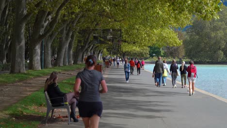 People-Walk-along-the-Promenade-Jacquet-on-a-autumn-day-by-the-Lac-d'Annecy-in-Annecy