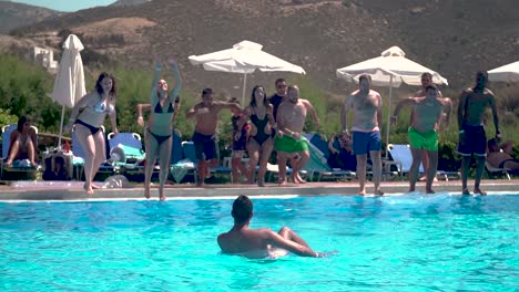 Grupo-De-Amigos-Saltando-A-Una-Piscina-En-Vacaciones-De-Verano,-Cámara-Lenta