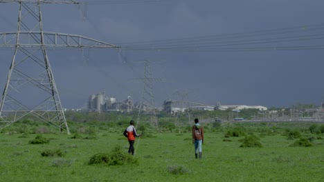 Two-black-men-walk-through-a-green-meadow-on-the-edge-of-a-city