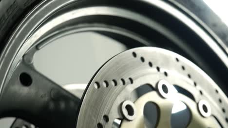 Close-Up-Of-Spinning-Motorbike-Disc-Brake-Inside-Workshop