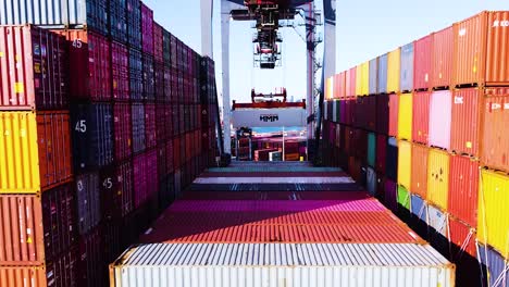 Cargo-ship-being-loading-with-shipping-containers-while-docked-at-port-near-New-York-City---Close-up-Aerial-footage