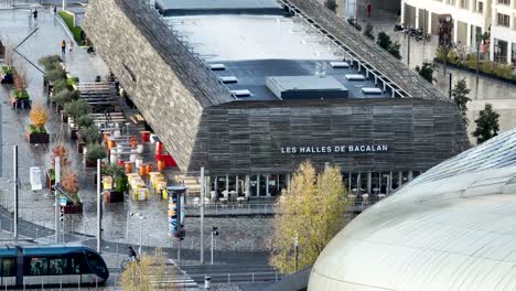 Les-Halles-de-Bacalan-specialty-gourmet-food-market-on-the-Quai-du-Maroc-pier,-Aerial-pan-right-shot