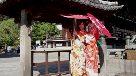 Dos-Hermosas-Geishas-Con-Sombrillas-Rojas-En-El-Templo