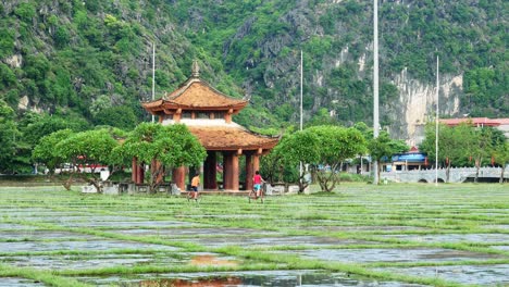 Two-children-on-bicycles-riding-in-a-Vietnamese-palace