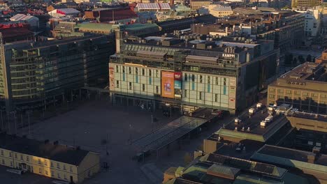 Vista-Aérea-Alrededor-Del-Centro-Comercial-Kamppi,-Soleado,-Amanecer-De-Verano,-En-Helsinki,-Finlandia---órbita,-Disparo-De-Drone