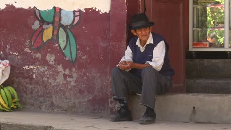 An-old-man-sits-on-the-steps-in-front-of-the-house-and-counts-small-coins