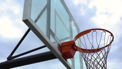 Mirando-Hacia-El-Tablero-De-Baloncesto-Deportivo-Urbano-Y-El-Aro-Contra-El-Cielo-Nublado