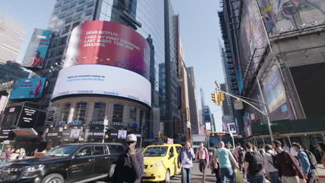 Ultra-Wide-shot-slow-motion-of-busy-intersection-car-driving-in-midtown-Manhattan