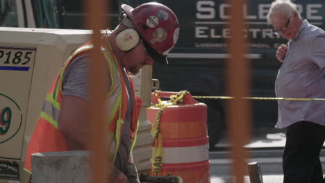 Close-Up-on-Construction-worker’s-Jackhammer-on-busy-Manhattan-midtown-street-in-slow-motion