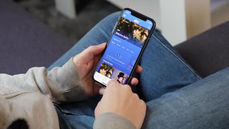 Young-woman-using-Sky-Go-app-on-an-iPhone-in-casual-home-environment