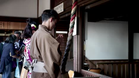 Japanese-couple-pray-at-a-Buddhist-temple