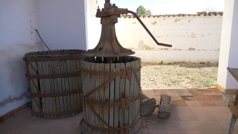 Dentro-De-Una-Casa-Antigua-Con-Un-Antiguo-Lagar-De-Madera,-Para-Hacer-Vino-Con-Uvas-Y-Un-Antiguo-Mecanismo-De-Reloj-Con-Un-Sistema-De-Pesas,-Dentro-De-Una-Habitación-De-Paredes-Blancas