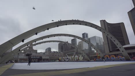 Patinadores-Sobre-Hielo-En-La-Plaza-Nathan-Phillips-De-Toronto-Con-El-Icónico-Cartel-De-&quot;Toronto&quot;-Y-El-Ayuntamiento-Al-Fondo