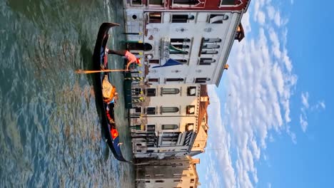 Toma-De-Paralaje-Vertical-De-Góndola-Con-Turistas-Cruzando-Lancha-Motora-En-Venecia.