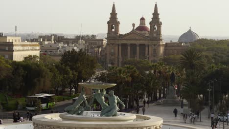 Mittlere-Aufnahme-Des-Tritonbrunnens-Am-Stadttor-Von-Valletta,-Im-Hintergrund-Die-Kirche-Des-Heiligen-Publius