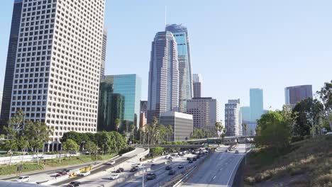 Rascacielos-Del-Centro-De-Los-Ángeles-Y-Tráfico-Diario-En-La-Autopista-Harbor-Freeway,-California