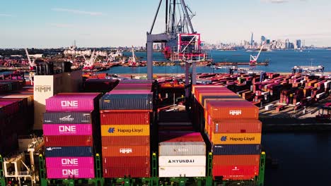 Cargo-ship-being-loading-with-shipping-containers-while-docked-at-port-near-New-York-City---Medium-distance-Aerial-footage