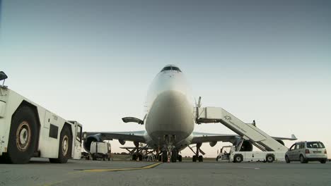 Bodennahe-Ansicht-Eines-Frachtflugzeugs-Mit-Ladeausrüstung-Im-Morgengrauen-Auf-Dem-Rollfeld-Eines-Flughafens