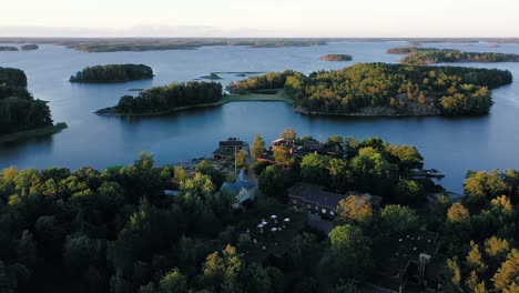 Aerial-view-towards-the-Tvarminne-zoological-station,-sunny,-summer-evening,-in-Hanko,-Finland---tilt-down,-drone-shot