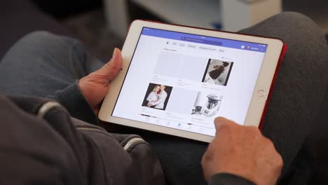 Hombre-Adulto-Medio-Navegando-Por-El-Mercado-De-Facebook-En-La-Aplicación-De-Un-IPad-En-Un-Ambiente-Hogareño-Informal