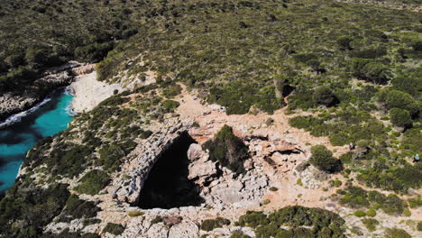 Un-Disparo-De-Un-Dron-Volando-Hacia-Adelante-Sobre-Un-Arco-Marino-Cerca-De-Cala-Varques-En-Mallorca